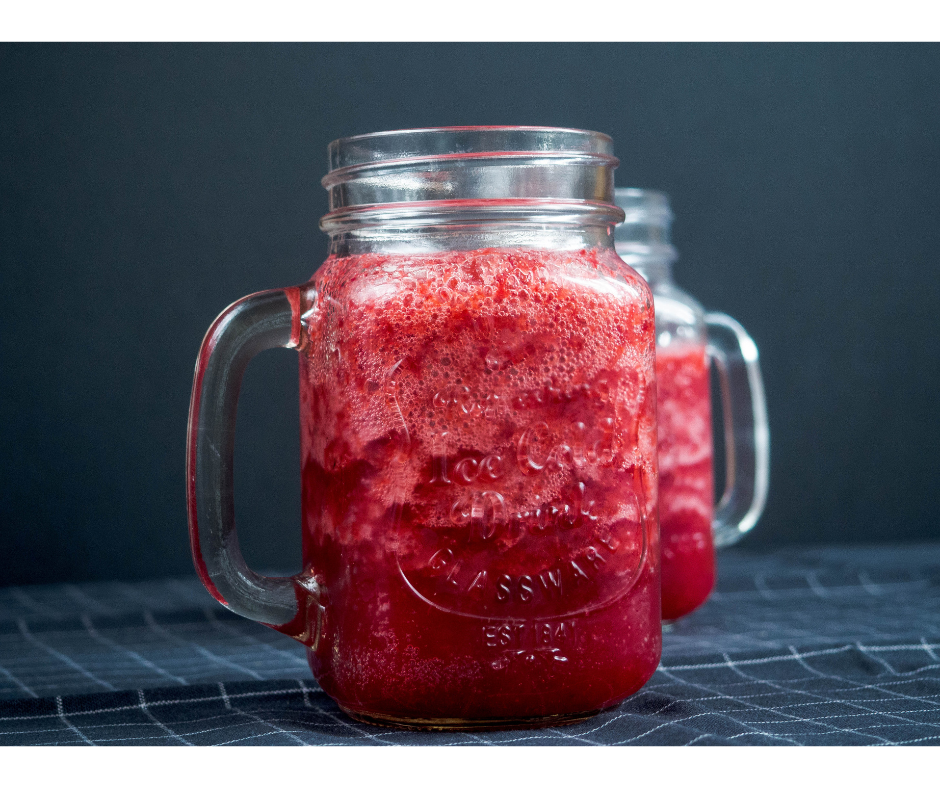 fermented beet kvass in mason jar glass sitting on navy blue table cloth with navy in the background